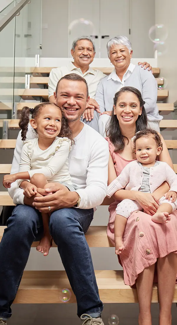 Multi-generational family seated together indoors, symbolizing personalized support, comfort, and care within a family setting.