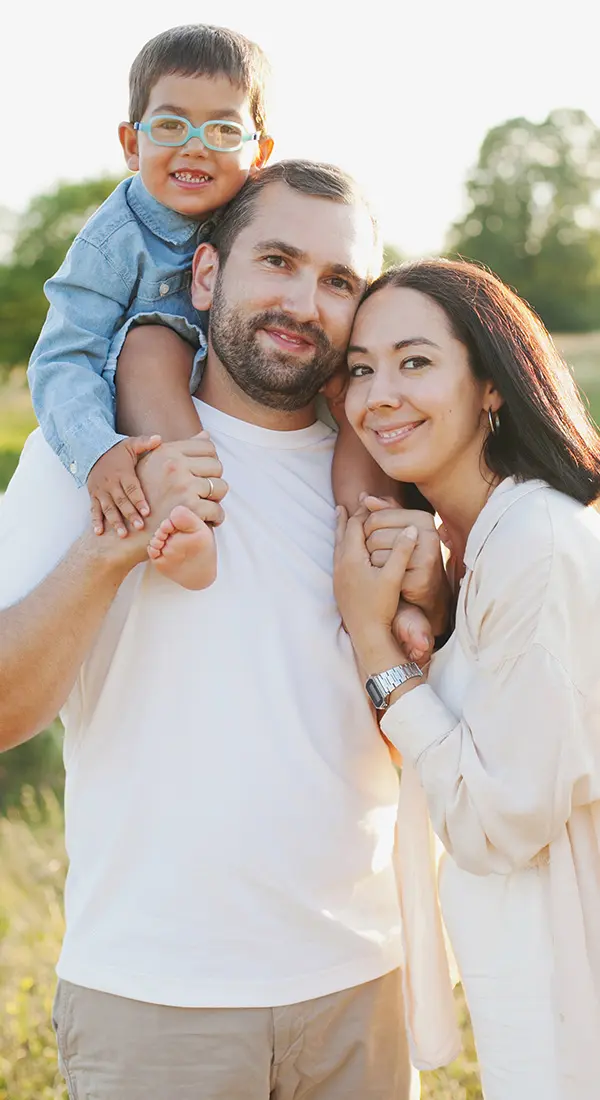 Happy family of three outdoors, symbolizing personalized care, bonding, and support for all ages.