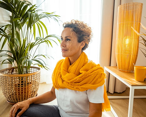 Woman practicing grounding and breathing exercises to manage anxiety in a calm home setting